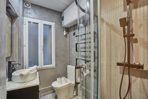 a bathroom with a toilet and a sink and a shower at Apartment Louvre museum by Studio prestige in Paris