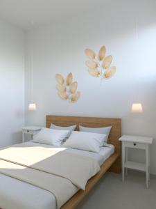 een slaapkamer met een bed en twee planten aan de muur bij Fenici Levanzo - Island Apartments in Levanzo