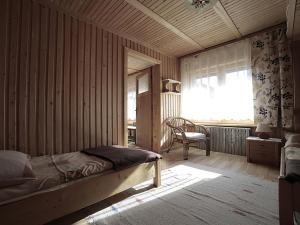 a bedroom with a bed and a chair and a window at Pod Strzechą in Białka Tatrzańska
