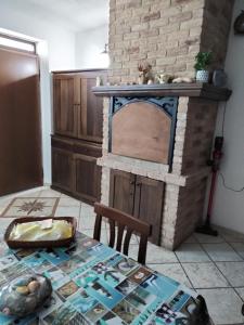 a living room with a brick fireplace and a table at casetta sul porticciolo in Stintino