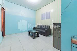 Banjarbaru的住宿－Ana Guest House Syariah Mitra RedDoorz，客厅配有沙发和桌子