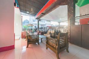 un restaurante con 2 sillas y una mesa en una habitación en Ana Guest House Syariah Mitra RedDoorz en Banjarbaru