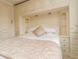 Thornton的住宿－23 Wolsey Close，卧室配有一张带橱柜的大型白色床。
