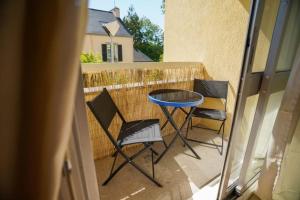 a patio with a table and chairs on a balcony at Studio Majorelle in Quimper