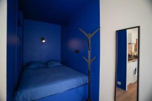 a blue bedroom with a bed and a mirror at Studio Majorelle in Quimper