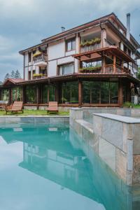 a house with a swimming pool in front of a building at Guest House Valevtsi in Valevtsi