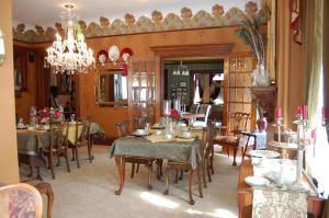 a dining room with tables and chairs and a chandelier at Schuster Mansion Bed & Breakfast in Milwaukee