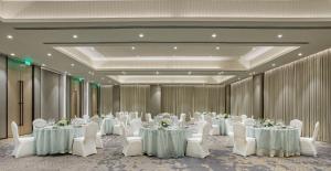 a banquet hall with white tables and white chairs at Fairfield by Marriott Vadodara in Vadodara