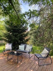 2 sillas y una mesa en una terraza de madera en Le Hameau, en Florent-en-Argonne
