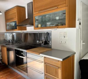 a kitchen with wooden cabinets and a stove top oven at LODGE CAP in Lège-Cap-Ferret