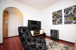 a living room with a chair and a tv at Gairdner Cottage - something a bit different! in Albany