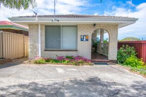 a brick house with a gate and a driveway at Gairdner Cottage - something a bit different! in Albany