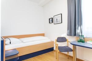una camera da letto con un letto, una scrivania e una sedia di JUFA Hotel Garni Stubenberg am See a Stubenberg