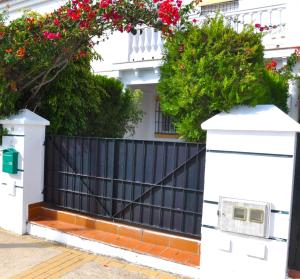 a black fence with red flowers on a house at Casa Lea in Islantilla