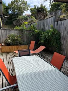een tafel en stoelen op een terras met een hek bij LODGE CAP in Lège-Cap-Ferret