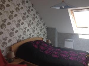 Schlafzimmer mit einem Bett mit rosa Bettwäsche und einem Fenster in der Unterkunft RÉF 324 LARMOR-PLAGE DERNIER ÉTAGE VUE MER PARKING in Larmor-Plage