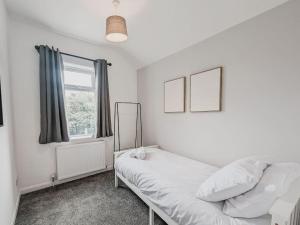 a white bedroom with a bed and a window at Valley Park House - By Sigma Stays in Crewe