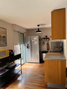 een keuken met een koelkast en een houten vloer bij LODGE CAP in Lège-Cap-Ferret +3 foto's