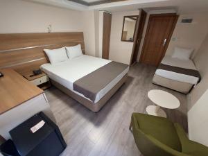 Habitación de hotel con cama, escritorio y silla en BEYAZ İNCİ OTEL en Sivas