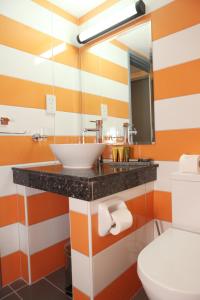 baño con rayas anaranjadas y blancas en Kefalos Damon Hotel Apartments, en Pafos