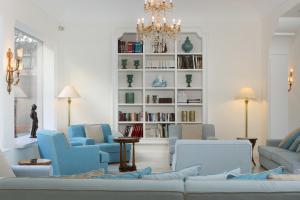 a living room with blue chairs and a chandelier at Grand Hotel de la Ville in Sorrento