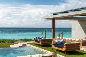 a resort with a pool and chairs and the ocean at Cap Karoso Sumba - a member of Design Hotels 
