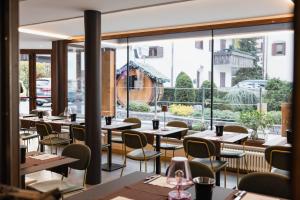 a restaurant with tables and chairs and a large window at Olimpia Hotel in Bormio +262 photos