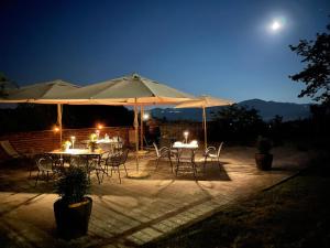 a group of tables and chairs under umbrellas at night at La Cantinetta Resort in Mombello Monferrato