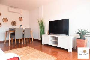 una sala de estar con TV en un armario blanco en Larala 03 - Nuevo apartamento frente al mar en el Arenal en Jávea, en Jávea