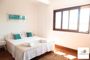 Un dormitorio blanco con una cama con toallas. en Larala 03 - Nuevo apartamento frente al mar en el Arenal en Jávea, en Jávea