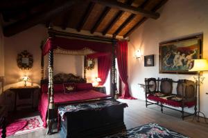 1 dormitorio con cama con dosel y silla en Hotel Castello Di Vigoleno, en Vigoleno