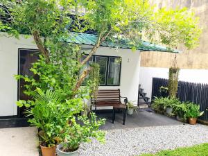 un banc en bois assis devant une maison ornée de plantes dans l'établissement Home From Home, à Nugegoda