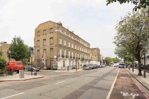 una calle urbana vacía con un gran edificio de ladrillo en Camden Apartment By Morethanstays, en Londres