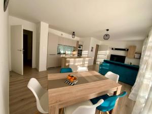 een woonkamer met een tafel en stoelen en een keuken bij L'appel du large in Arzon