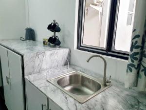 um lavatório de prata numa cozinha com uma janela em Home From Home em Nugegoda