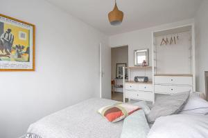 a white bedroom with a bed and a dresser at Appt agréable avec balcon au sud-ouest de Caen in Caen