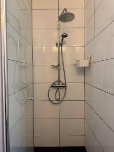 a shower with a shower head in a bathroom at Lolula Homy in Bergen