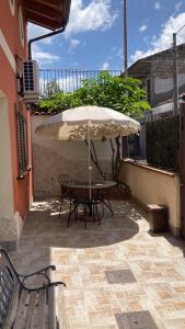 a table and chairs under an umbrella on a patio at Stanza Luna in Ragalna