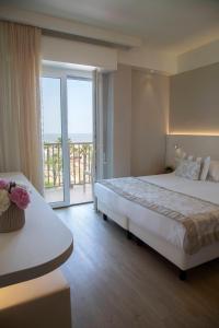 a hotel room with a large bed and a balcony at Hotel Mon Cheri in Riccione