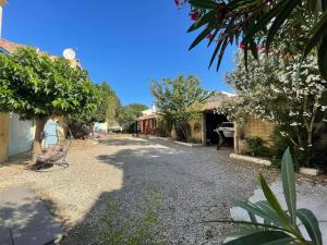 a gravel driveway in a yard with trees and houses at Velezia LOVE in Roujan