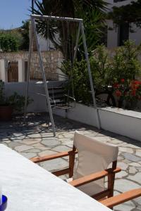 un par de sillas y un columpio en un patio en Aristidis en Galissas