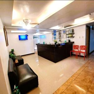 a lobby with a waiting room with a counter and chairs at Makati Poblacion Hotel in Manila