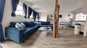 a living room with a blue couch and a table at Vakantiehuis de Ankerplaats in Kamperland