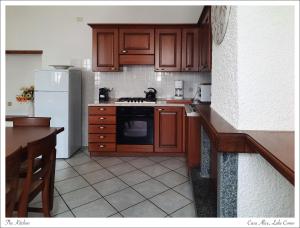 uma cozinha com armários de madeira e um frigorífico branco em Azalea di Gigliola Ziello - "Casa Alice" em Cremia