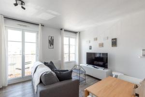 a living room with a couch and a tv at Studio cosy, 4Pers, wifi, proche Disney, Parking - Fairytale Factory in Bussy-Saint-Georges