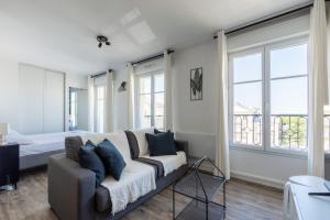 a living room with a couch and some windows at Studio cosy, 4Pers, wifi, proche Disney, Parking - Fairytale Factory in Bussy-Saint-Georges