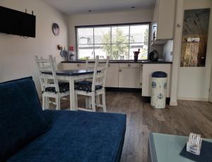 - un salon avec une cuisine, une table et des chaises dans l'établissement Vakantiehuis de Ankerplaats, à Kamperland