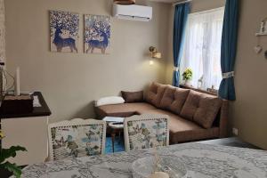 a living room with a couch and a table and chairs at Borostyánkút Wellness Home Bakonybél in Bakonybél