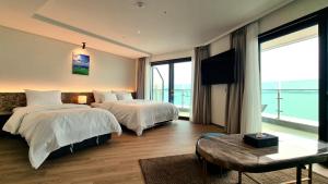 a hotel room with two beds and a large window at Hotel GITE in Siheung
