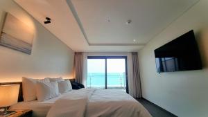 a bedroom with a large bed with a television on the wall at Hotel GITE in Siheung